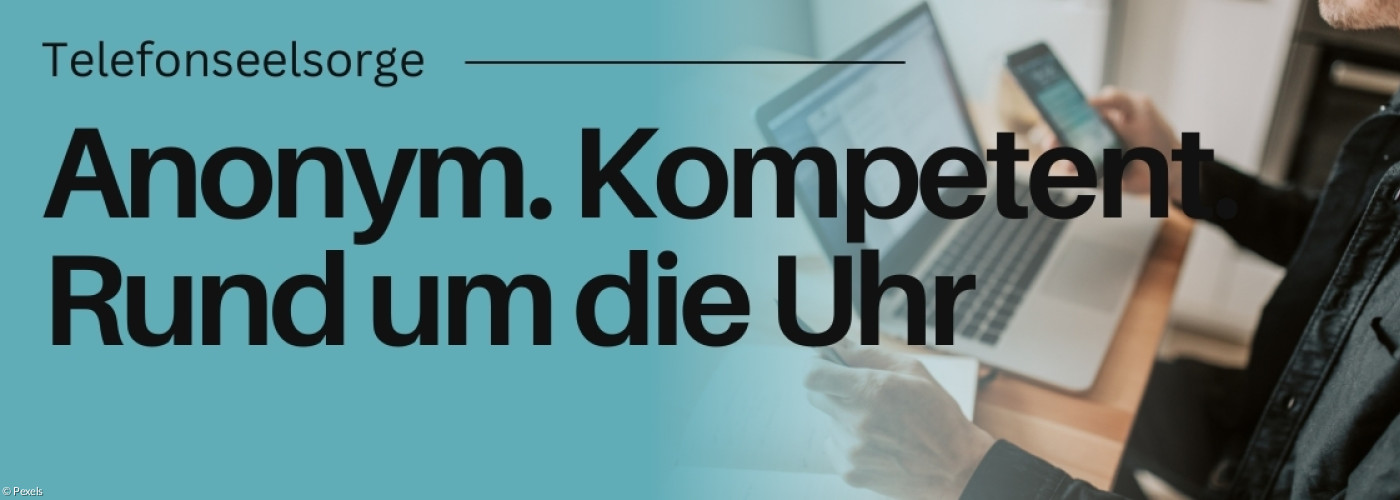 Jemand vor Laptop und Handy an einem Tisch.