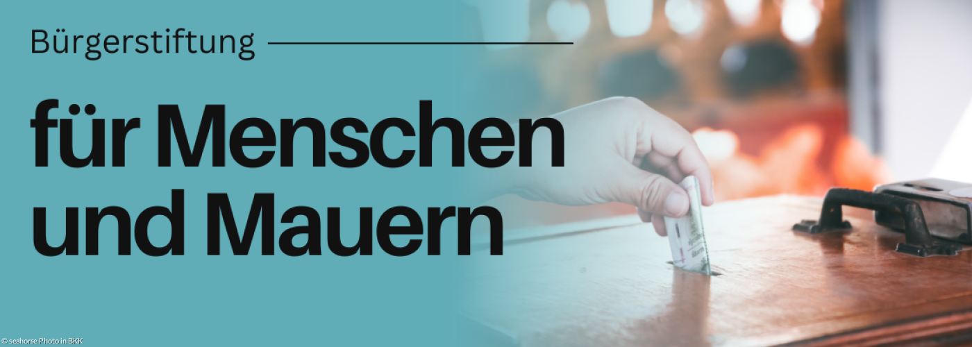 Hand schmeißt Geld in einen Opferstock.