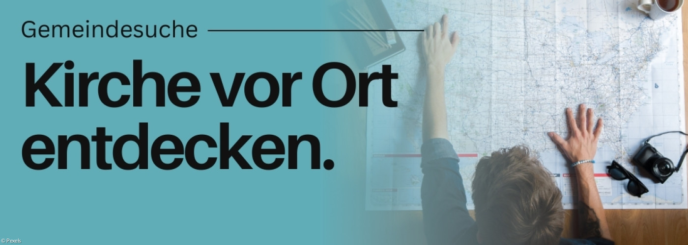 Jemand hat eine Karte vor sich liegen und daneben eine Fernglas.