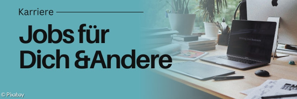 Schreibtisch mit Laptop darauf.