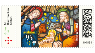 Motiv eines Buntglasfensters mit Maria und Josef neben der Krippe mit dem Christuskind und Ochs und Esel.