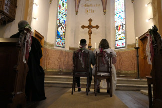 Ehepaar sitzt auf 2 Stühlen nebeneinander vor dem Altar in der Matthäuskirche Kelheim
