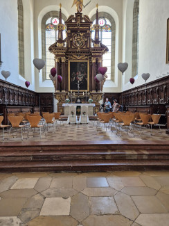 Der geschmückte Altarraum der Dreieinigkeitskirche mit Luftballons und Brautstühlen. Dabei steht die Band Vesto, die die Zeremonien musikalisch begleitet hat.