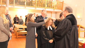 Dekan Jörg Breu und die Assistierenden segnen Pfrin Ingrid Erichsen für ihren Dienst