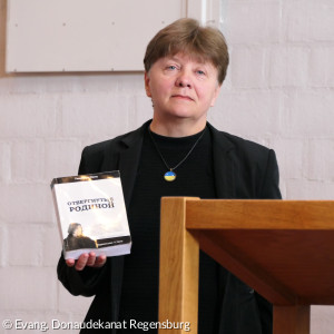Kirchenvorständin Nina zeigt das gerettete Buch aus der ausgebrannten Kirche